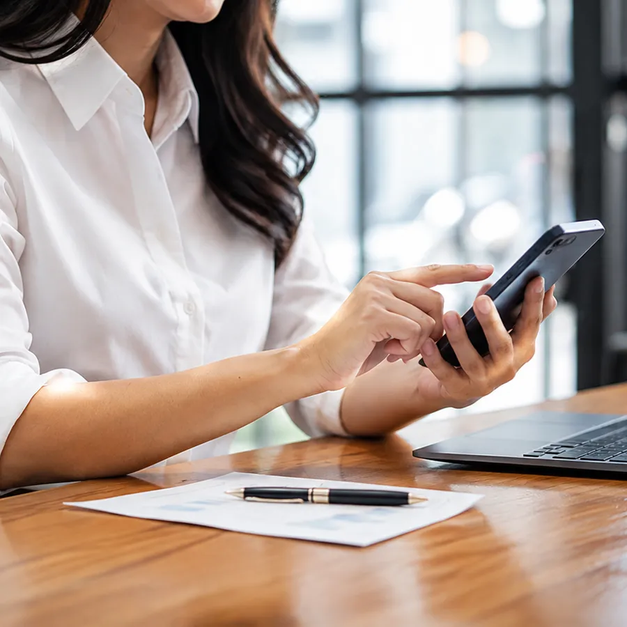 Relatório com gráficos sobre a mesa e o celular em consulta